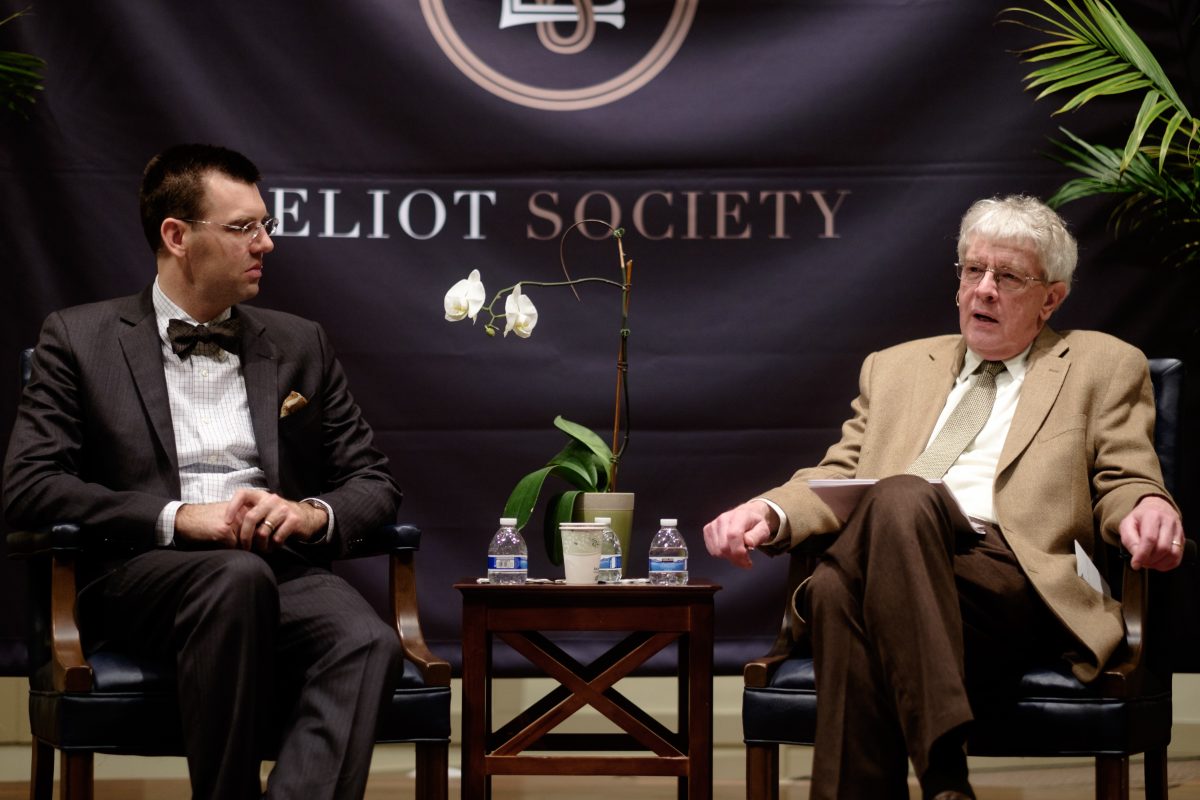 An on-stage conversation beneath the Eliot Society banner