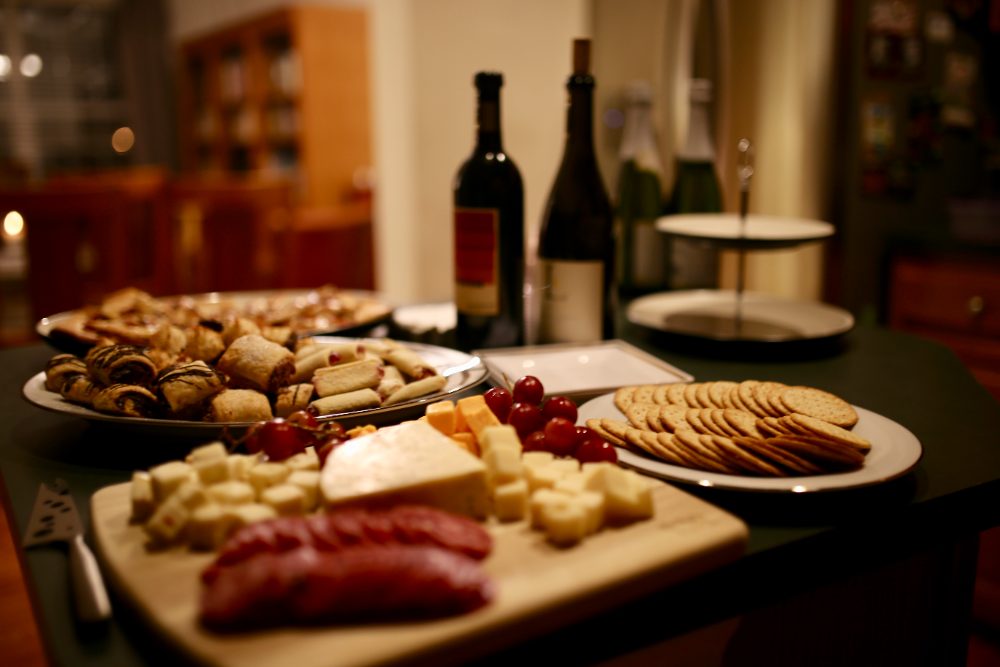 Wine, cheese, and pastries laid out for a living room evening